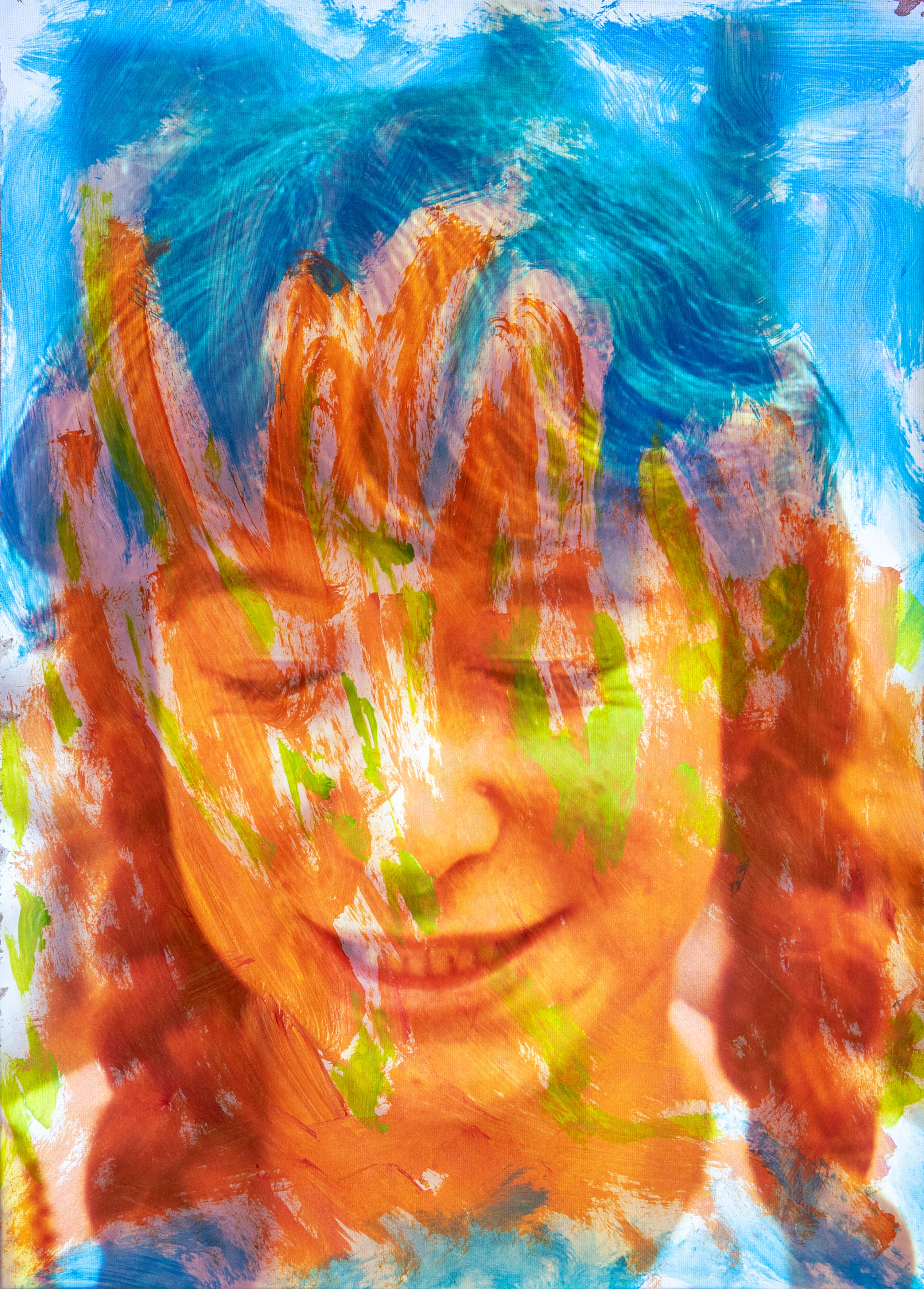 A smiling girl with red curly hair, covered in blue and orange paint strokes.