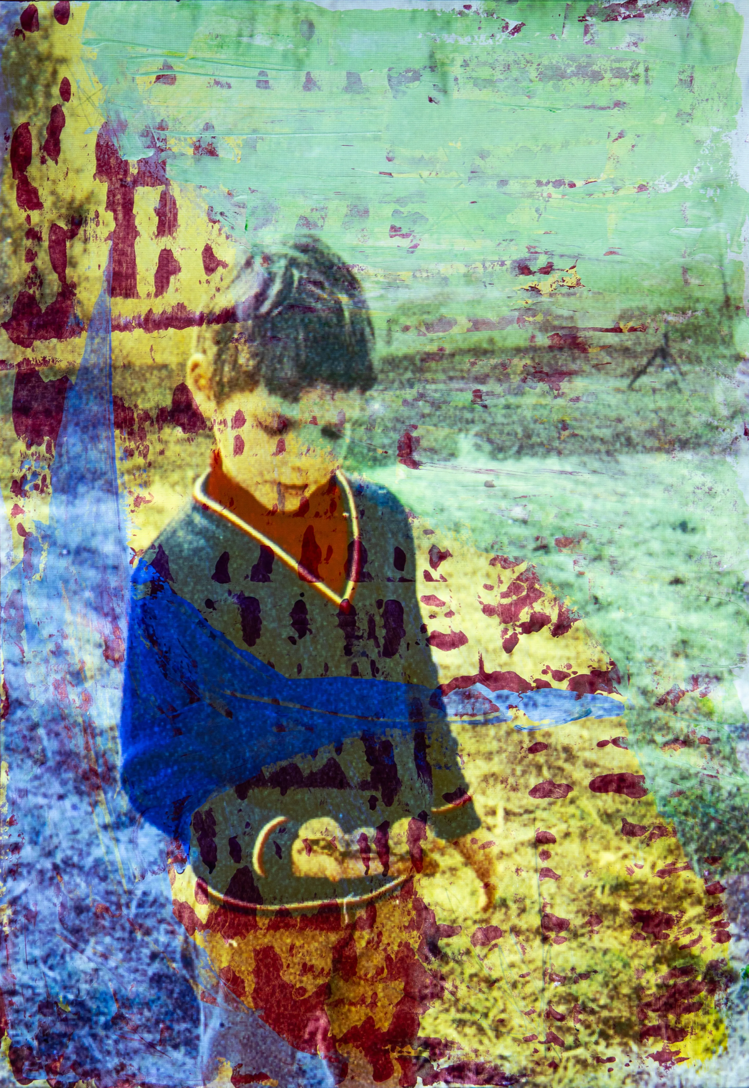 A young boy in a dark sweater stands in a field, with blue, green and red brush marks over him.