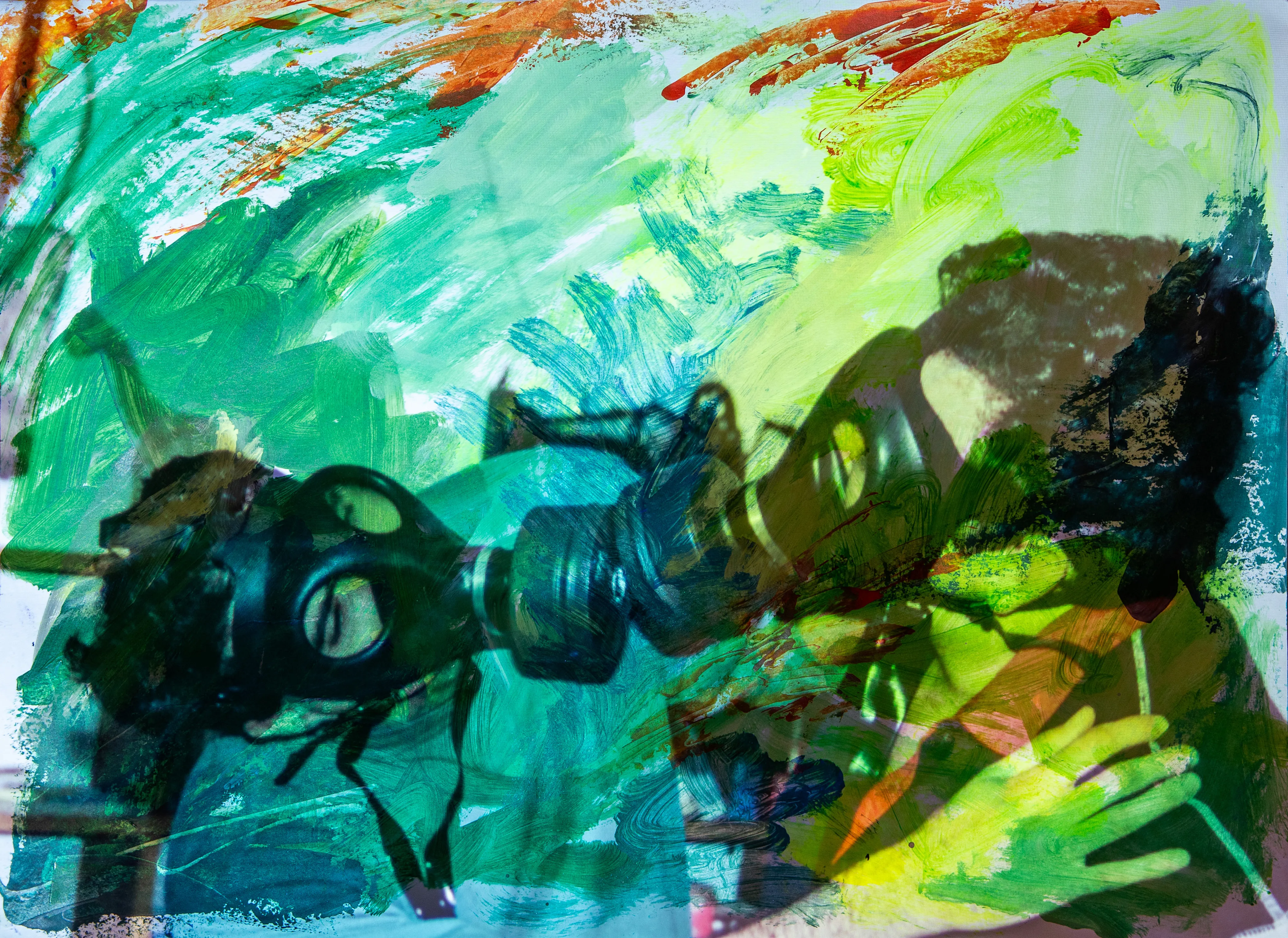 Two figures in gas masks face each other against green, turquoise and orange paint.