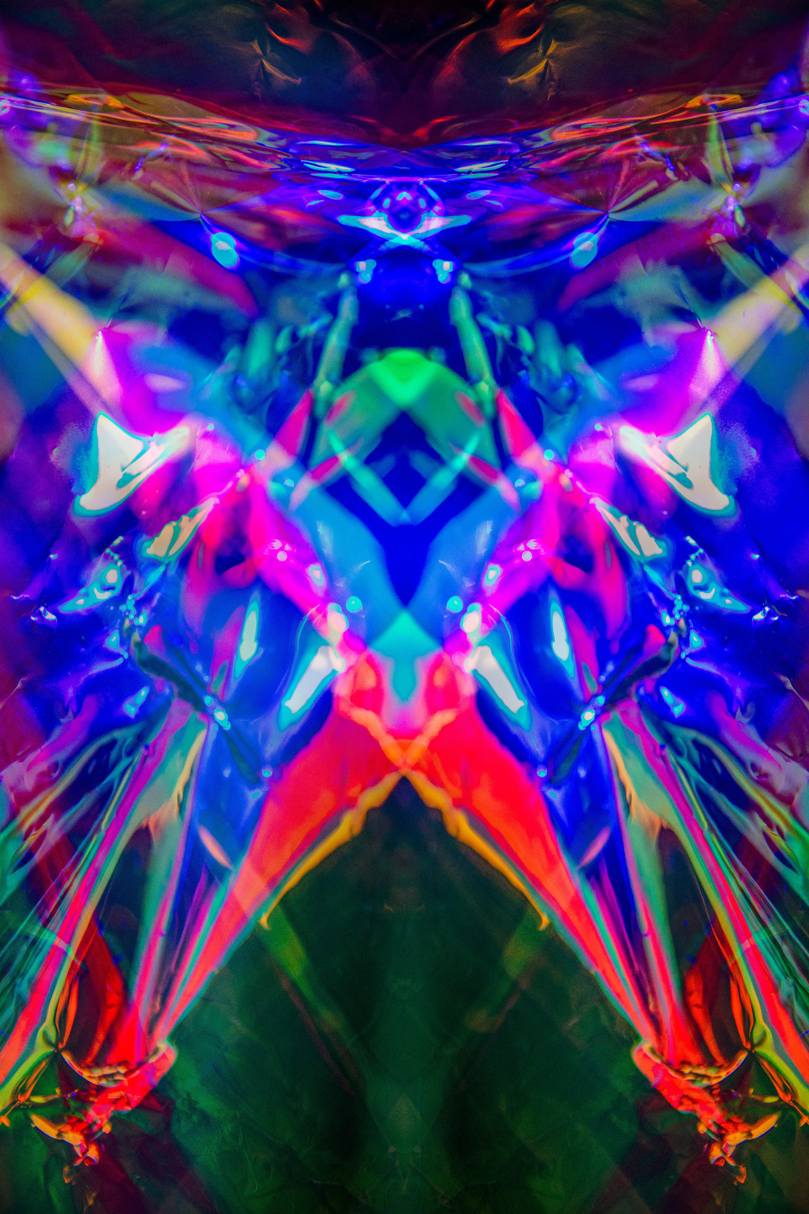 A tall mirrored composition in electric blue with red and pink streaks forming a V, and green at the center.