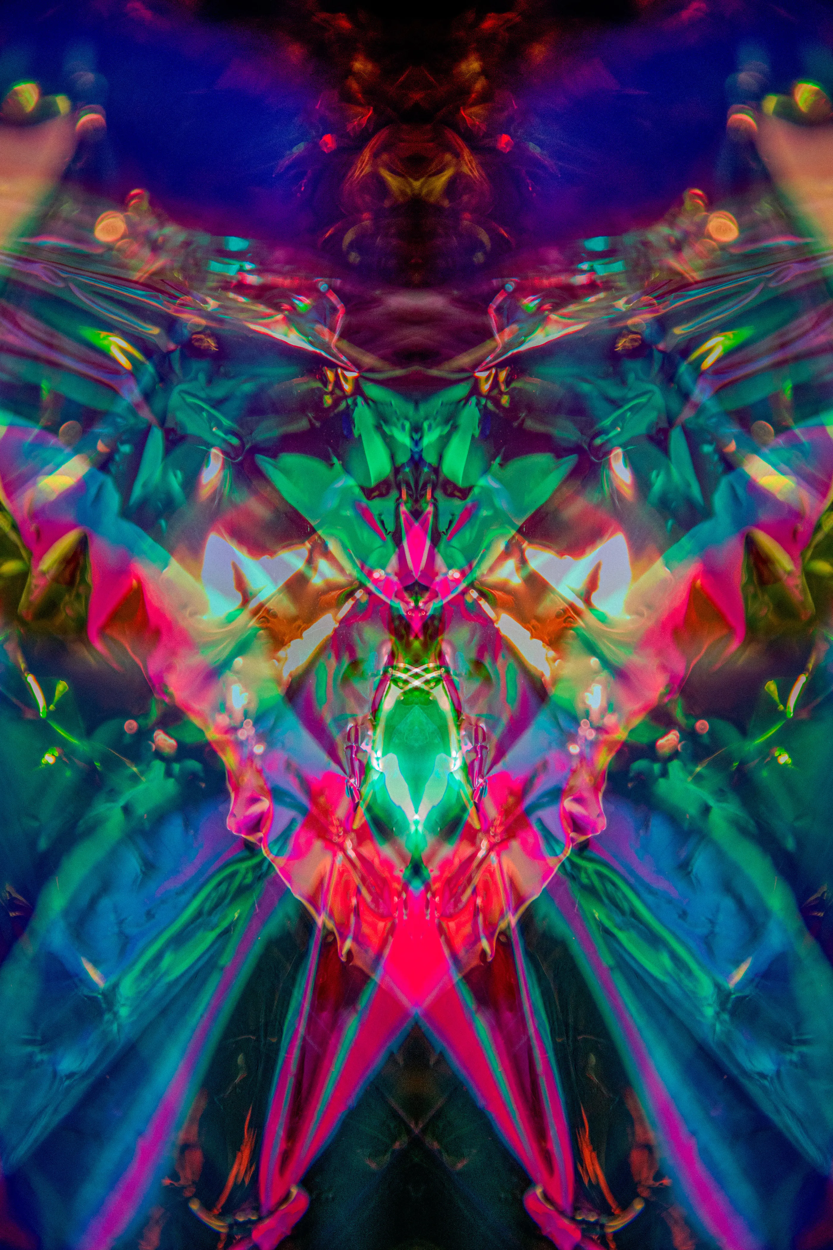 A tall mirrored composition in teal, blue, green and pink, with pink diagonals meeting low at the center.